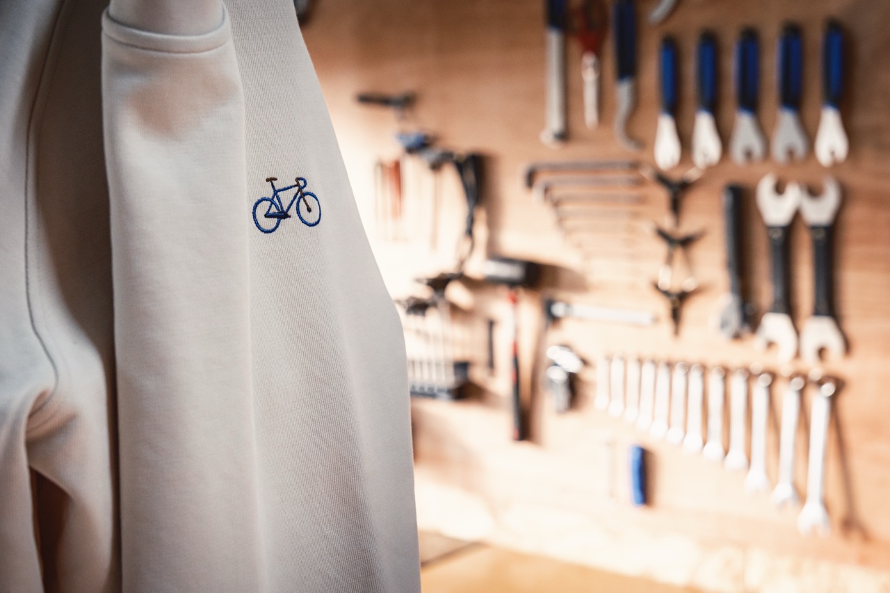 Trui met fiets in geborduurd. achtergrond muur met tools